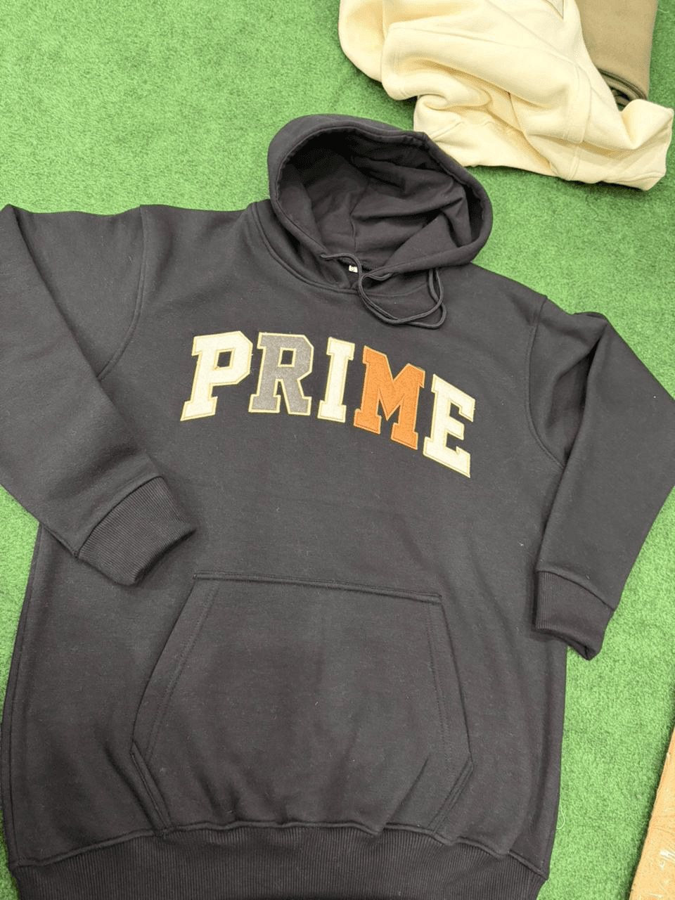 Black Prime Apparel hoodie with embroidered varsity letter patch design