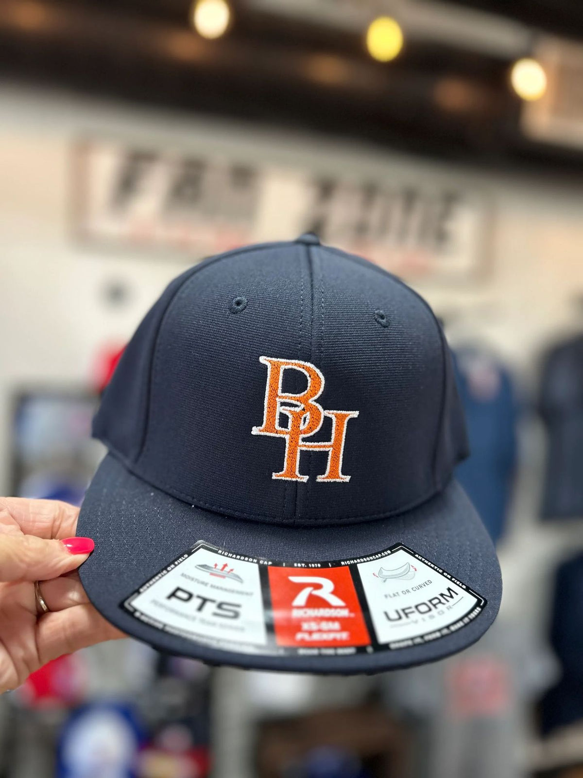 Custom navy snapback hat with embroidered orange BH logo, Prime Apparel headwear